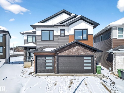 The property features a contemporary exterior with multi-toned siding, dark-framed windows, and a prominent double garage with modern doors - 6614 39 Avenue, Beaumont, AB - Outdoor