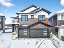 The property features a contemporary exterior with multi-toned siding, dark-framed windows, and a prominent double garage with modern doors - 6614 39 Avenue, Beaumont, AB  - Outdoor 
