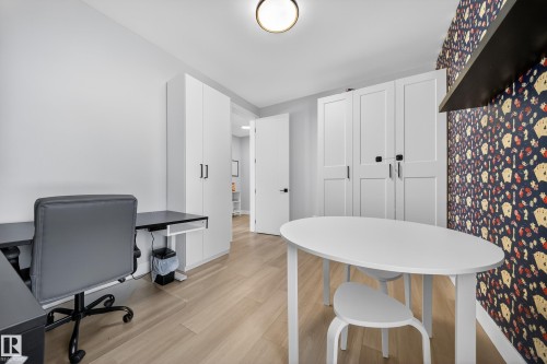 This versatile room features light-toned wood flooring, white walls, and a recessed ceiling light - 6614 39 Avenue, Beaumont, AB - Indoor Photo Showing Office