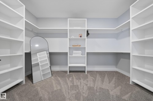 The property features an expansive closet with built-in white shelving and hanging rods - 6614 39 Avenue, Beaumont, AB - Indoor With Storage