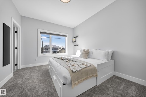 This room features light grey walls, grey carpet flooring, and a window providing natural light - 6614 39 Avenue, Beaumont, AB - Indoor Photo Showing Bedroom