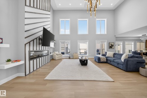 Spacious living area featuring high ceilings, light-toned hardwood flooring, and large windows providing ample natural light - 6614 39 Avenue, Beaumont, AB - Indoor