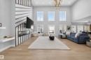 Spacious living area featuring high ceilings, light-toned hardwood flooring, and large windows providing ample natural light - 6614 39 Avenue, Beaumont, AB  - Indoor 