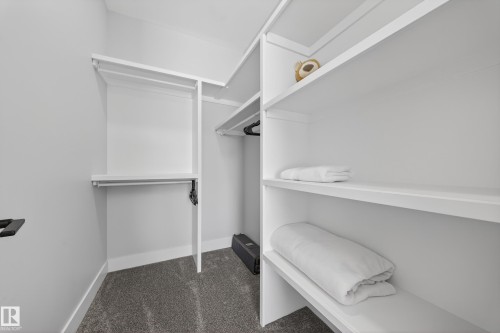 The property features a closet with white built-in shelving and hanging rods - 6614 39 Avenue, Beaumont, AB - Indoor With Storage