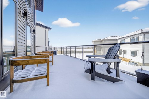 This expansive outdoor deck features a glass railing, providing clear views of the surroundings - 6614 39 Avenue, Beaumont, AB - Outdoor With Exterior