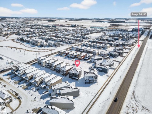 Aerial view of the community, showcasing surrounding properties and a nearby road - 6614 39 Avenue, Beaumont, AB - Outdoor With View