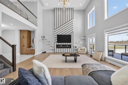 Spacious living area featuring high ceilings, light hardwood floors, and large windows that provide abundant natural light - 6614 39 Avenue, Beaumont, AB - Indoor