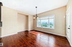 Spacious interior room featuring wood-finish flooring, a large window offering expansive outdoor scenery, a decorative chandelier, and a built-in architectural niche - 