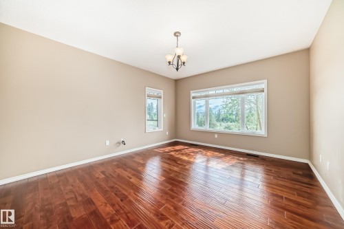 Spacious room featuring rich wood-finish flooring and neutral painted walls - 527 Callaghan Point(E), Edmonton, AB - Indoor Photo Showing Other Room