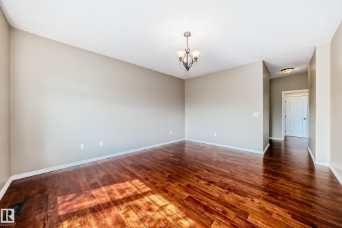 Spacious room featuring rich wood-finish flooring, a traditional chandelier, recessed lighting, and neutral wall tones - 527 Callaghan Point(E), Edmonton, AB - Indoor Photo Showing Other Room