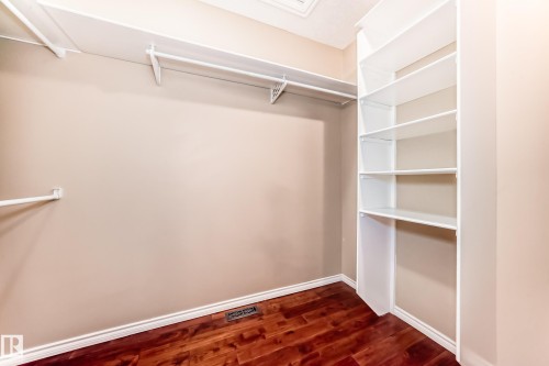 Custom closet system featuring wood-finish flooring, white baseboards, and built-in shelving units - 527 Callaghan Point(E), Edmonton, AB - Indoor With Storage