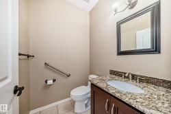 Powder room featuring a dark wood vanity with a granite countertop, undermount sink, and brushed nickel faucet - 