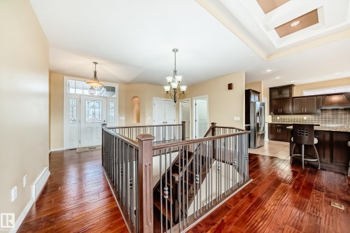 Hardwood flooring extending from the entryway throughout the main level, complemented by a recessed tray ceiling feature - 527 Callaghan Point(E), Edmonton, AB - Indoor Photo Showing Other Room