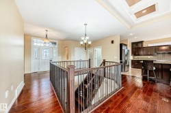 Hardwood flooring extending from the entryway throughout the main level, complemented by a recessed tray ceiling feature - 