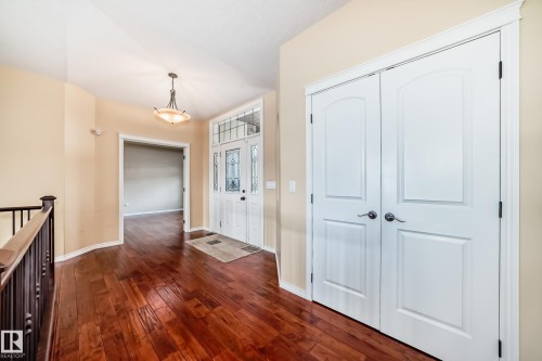 Entryway featuring wood-finish flooring, a decorative front door with sidelights and transom, and a pendant light fixture - 527 Callaghan Point(E), Edmonton, AB - Indoor Photo Showing Other Room