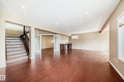 Expansive open-concept room featuring wood-finish flooring, recessed lighting, and neutral wall tones - 