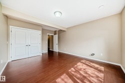 Spacious room featuring rich wood-finish flooring, neutral wall tones, and white trim - 