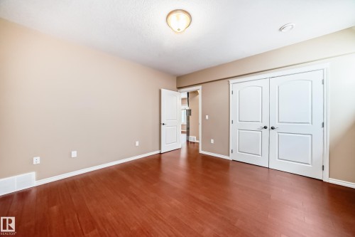 Spacious room featuring wood-finish flooring, neutral-toned walls, and white baseboards - 527 Callaghan Point(E), Edmonton, AB - Indoor Photo Showing Other Room