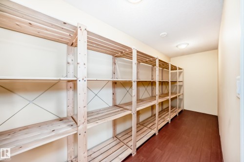 Dedicated storage room featuring extensive wood shelving, durable wood-finish flooring, and ceiling-mounted lighting - 527 Callaghan Point(E), Edmonton, AB - Indoor