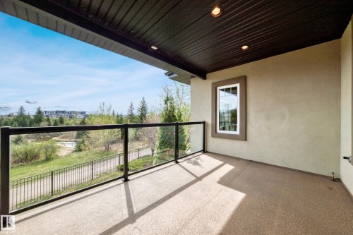 Covered balcony with a glass railing system, textured flooring, and recessed lighting - 527 Callaghan Point(E), Edmonton, AB - Outdoor With Exterior