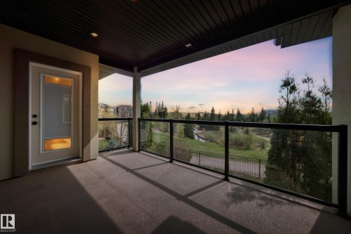 Covered balcony with glass railings and dark-finish decking - 527 Callaghan Point(E), Edmonton, AB - Outdoor With View With Exterior
