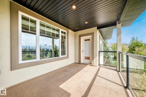 Covered outdoor patio featuring a textured floor, glass panel railing, and recessed lighting - 527 Callaghan Point(E), Edmonton, AB - Outdoor With Exterior