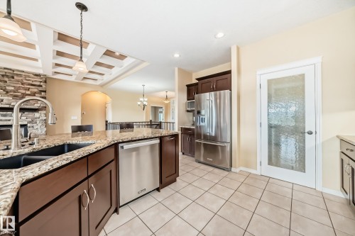 Kitchen featuring an island with a double basin sink, granite-style countertops, and rich wood cabinetry - 527 Callaghan Point(E), Edmonton, AB - Indoor Photo Showing Kitchen With Double Sink With Upgraded Kitchen