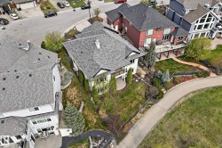 White exterior residence featuring a multi-level roofline with grey shingles - 