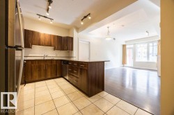 Kitchen featuring wood-finish cabinetry, stainless steel appliances, and a tiled backsplash - 