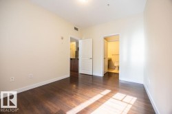 Spacious room featuring rich wood-finish flooring, light-toned walls, and bright white trim - 