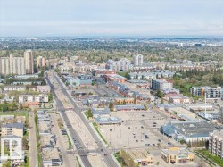 Expansive aerial perspective showcasing a developed urban landscape with diverse architectural styles, including multi-story residential buildings and commercial structures - 