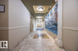 Hallway featuring a decorative mosaic wall art, recessed lighting, and a coffered ceiling with flush mount fixtures - 