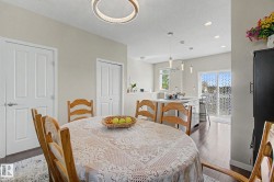 Dining area featuring a contemporary circular chandelier and wood-finish flooring - 