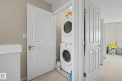 Dedicated laundry closet featuring a stacked washer and dryer unit - 