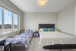 Bright room featuring a large window, neutral wall paint, and light-colored carpeting - 
