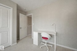 Carpeted room featuring a neutral color palette, white trim, and a white paneled door - 