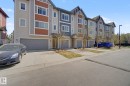 Contemporary townhome exterior featuring multi-level architecture with distinct siding patterns and colors, individual garage entrances, private driveways, and covered front entryways - 17 320 Secord Boulevard, Edmonton, AB  - Outdoor With Facade 