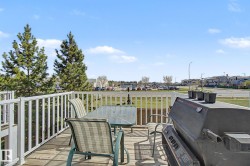 Spacious elevated deck featuring wood-finish flooring and a white railing system - 