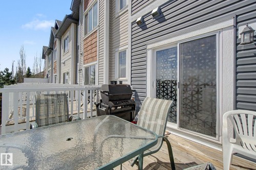Wood-finish deck with white railings and direct access to the interior via sliding glass doors - 17 320 Secord Boulevard, Edmonton, AB - Outdoor