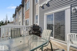 Wood-finish deck with white railings and direct access to the interior via sliding glass doors - 
