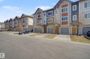 Contemporary townhome exterior featuring multi-toned siding, gabled rooflines, a private driveway, and an attached garage - 17 320 Secord Boulevard, Edmonton, AB  - Outdoor With Facade 