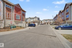 Multi-level residential buildings featuring red and beige siding, gabled rooflines, and multiple windows - 