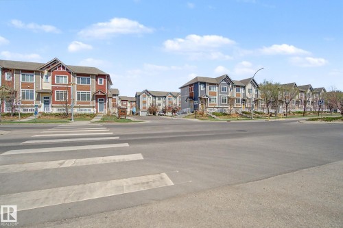 Contemporary townhome community featuring diverse exterior finishes, multiple gables, and prominent windows - 17 320 Secord Boulevard, Edmonton, AB - Outdoor With Facade