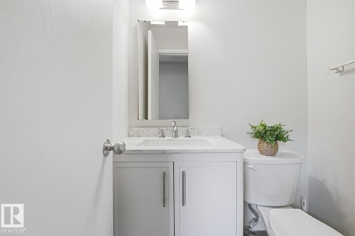 Bathroom featuring a white vanity with a stone countertop, an undermount sink, and a chrome faucet - 17604 85 Avenue, Edmonton, AB - Indoor