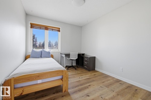 Bright room featuring light wood-finish flooring and a window with wood blinds - 17604 85 Avenue, Edmonton, AB - Indoor Photo Showing Bedroom