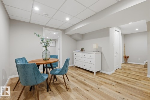 Spacious room featuring wood-finish flooring, light grey walls, and a white drop ceiling with recessed lighting - 17604 85 Avenue, Edmonton, AB - Indoor Photo Showing Dining Room