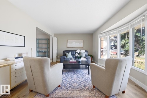 Bright living area featuring a large bay window with multiple panes, light wood-finish flooring, and neutral wall tones - 17604 85 Avenue, Edmonton, AB - Indoor Photo Showing Living Room