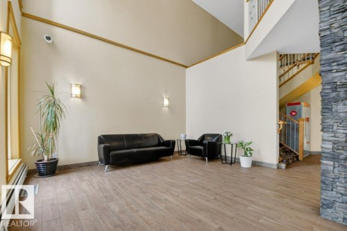 Spacious entryway featuring high vaulted ceilings and a stone-clad architectural columns - 223 10121 80 Avenue, Edmonton, AB - Indoor Photo Showing Other Room