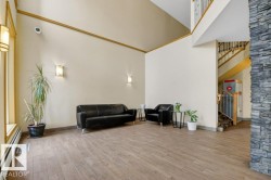 Spacious entryway featuring high vaulted ceilings and a stone-clad architectural columns - 