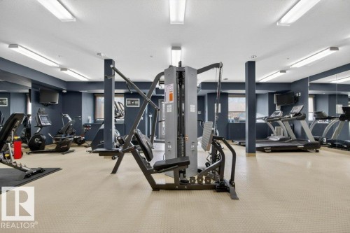 Fitness center featuring multiple exercise machines, mirrored walls and recessed lighting. - 223 10121 80 Avenue, Edmonton, AB - Indoor Photo Showing Gym Room